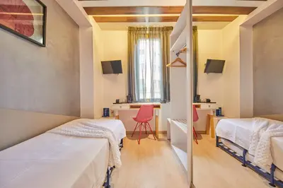 a room with two beds and a mirror at Hostemplo Sagrada Familia in Barcelona