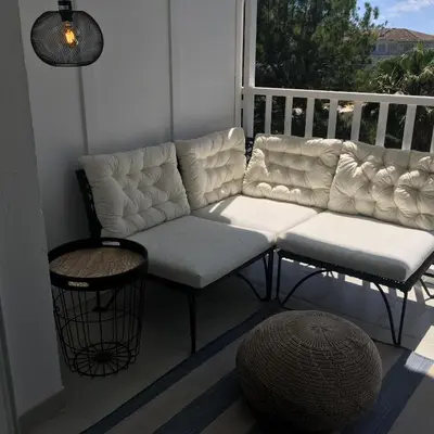 a couch and stool on a porch with a window at Tango in Sitges