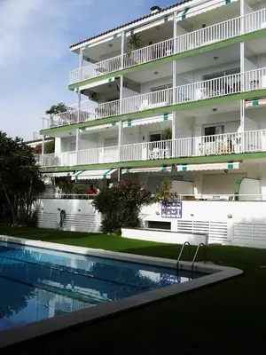 an apartment building with a swimming pool in front of it at Tango in Sitges
