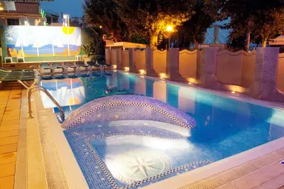a swimming pool at night with aperatureverningfficientfficientfficientfficient at Checkin Garbí in Calella