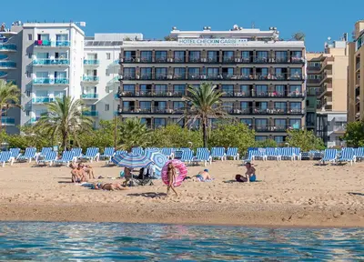 a group of people on a beach with a hotel at Checkin Garbí in Calella