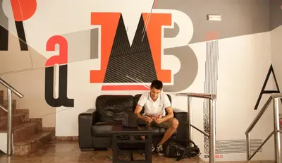 a man sitting on a chair in a room at Be Ramblas Guest House in Barcelona