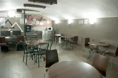 a restaurant with tables and chairs and a kitchen at Be Ramblas Guest House in Barcelona