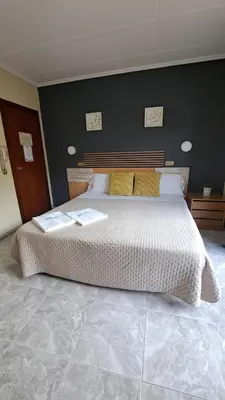 a bedroom with a large white bed with two pillows at Hotel Rodsan Suizo in Castelldefels