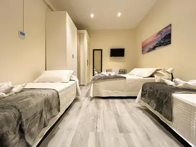 two beds in a room with wooden floors at Barcelona City Ramblas in Barcelona