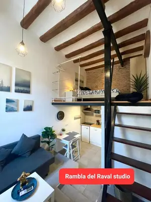 a living room with a blue couch and a loft at The Hipstel Parallel in Barcelona