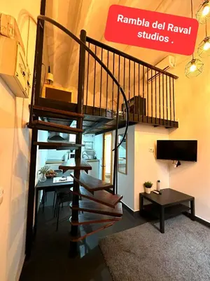a spiral staircase in a living room with a desk at The Hipstel Parallel in Barcelona