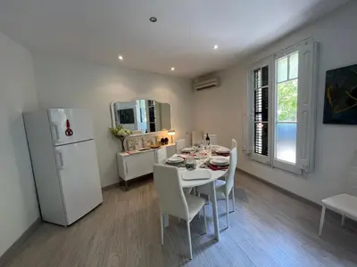 a dining room with a table and a white refrigerator at Barcelona 54 Apartment Rentals in Barcelona