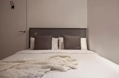 a white bed with a blanket on top of it at Centric Gracia Apartments in Barcelona
