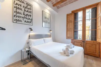 a bedroom with a white bed and a window at Centric Gracia Apartments in Barcelona