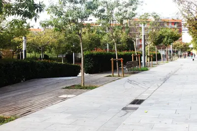 a sidewalk in a park with trees and bushes at Barcelona - Camp Nou in Hospitalet de Llobregat