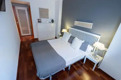 a bedroom with a large white bed and a wooden floor at Barcelona - Camp Nou in Hospitalet de Llobregat