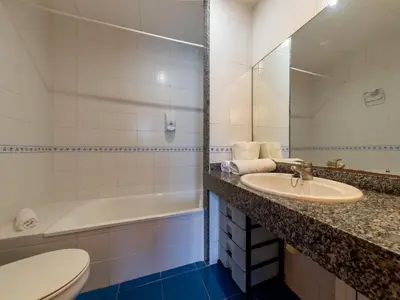 a bathroom with a sink and a tub and a toilet at Apartamentos Sunway Tara in Sitges