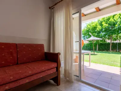 a living room with a couch and a sliding glass door at Apartamentos Sunway Tara in Sitges