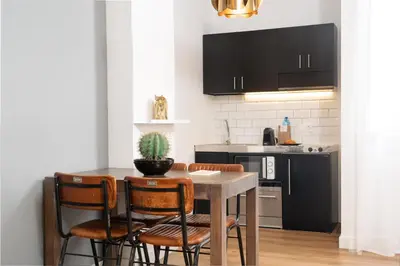 a kitchen with a table and chairs and a kitchen with black cabinets at TSA La Mare in Barcelona