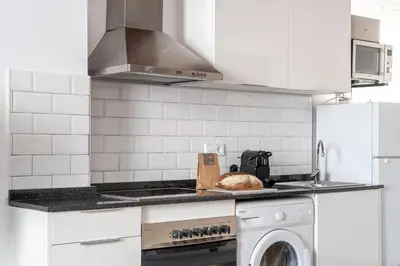 a kitchen with a stove top oven next to a dishwasher at TSA La Mare in Barcelona