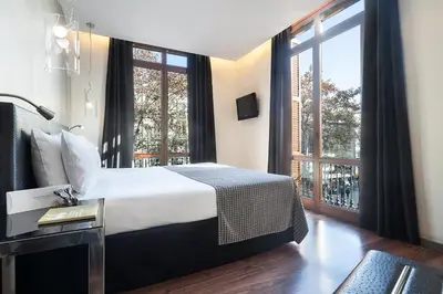 a hotel room with a bed and a large window at Dorma Ramblas Boquería in Barcelona