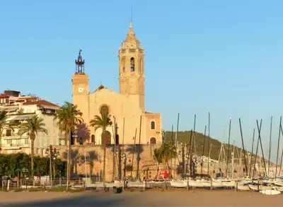 a large church with a tower and a clock at Sitges Center & Beach Espalter in Sitges
