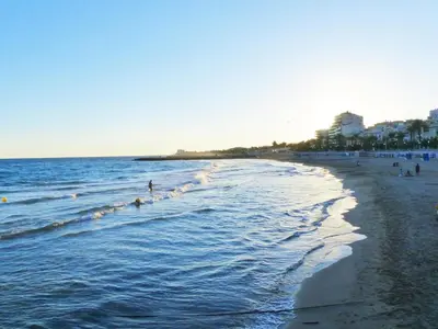 a beach with people in the water and people in the ocean at Sitges Center & Beach Espalter in Sitges