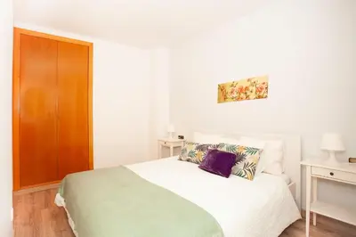 a bedroom with a white bed and a wooden cabinet at Sitges Center & Beach Espalter in Sitges