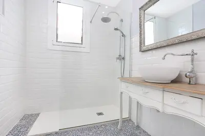 a white bathroom with a sink and a mirror at Gracia 1872 in Barcelona