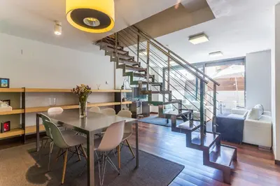 a dining room and living room with a spiral staircase at Apartment Barcelona Rentals - Swimming Pool with Terrace in Barcelona