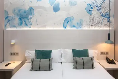 a bedroom with a white bed with two pillows at Hostal Operaramblas in Barcelona