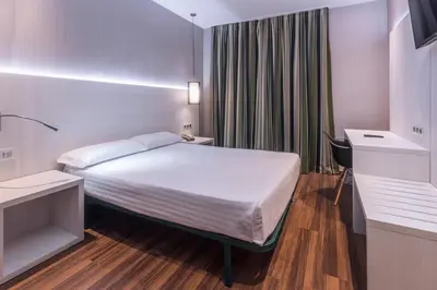 a hotel room with a bed and a desk at Hostal Operaramblas in Barcelona