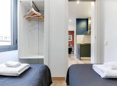 a bedroom with a bed and a bathroom with a mirror at City&Beach Apartments in City Center in Barcelona