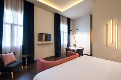 a hotel room with a bed and two chairs at Vincci Mae in Barcelona