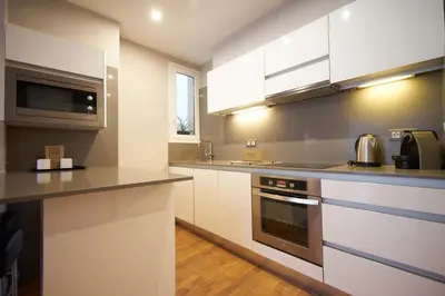 a kitchen with white cabinets and a microwave at Bonavista Apartments - Passeig de Gracia in Barcelona