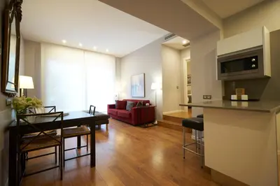 a living room with a table and a red couch at Bonavista Apartments - Passeig de Gracia in Barcelona