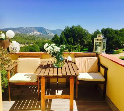 a wooden table with a vase of flowers on a balcony at Panoramic Apartments Sitges in Sitges