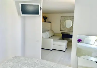 a white room with a bed and a couch at Panoramic Apartments Sitges in Sitges