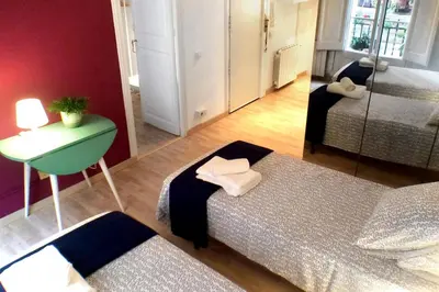 a room with two beds and a table and a room with a bed at Casa Tortilla Gracia in Barcelona
