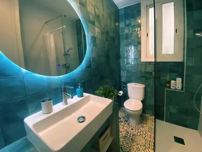 a bathroom with a sink and a toilet and a mirror at Casa Tortilla Gracia in Barcelona