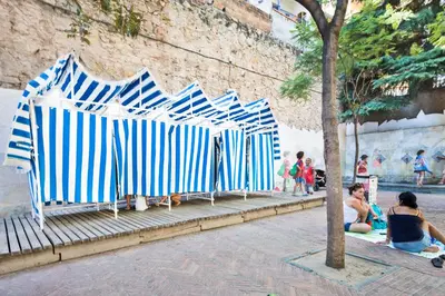 a row of blue and white chairs on a sidewalk at Habitat Apartments Garden View in Barcelona