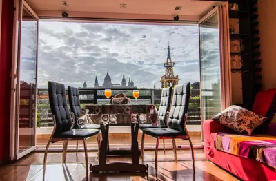 a room with a table and chairs and a large window at Unique Cozy Scenic Penthouse in Barcelona
