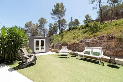 a yard with two lawn chairs and a house at Luxury Sitges Hills Villa in Olivella