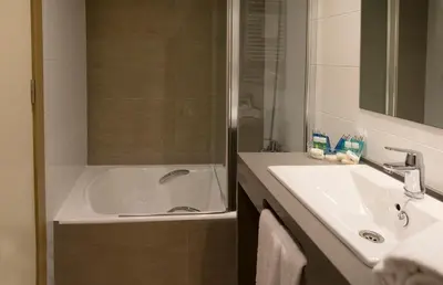 a bathroom with a tub and a sink and a shower at Apartamentos Voramar in Castelldefels