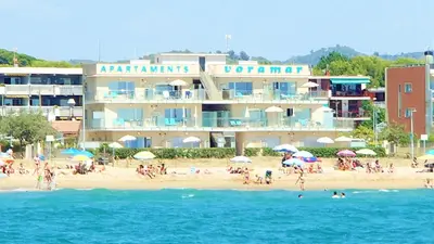 a group of people on the beach near a hotel at Apartamentos Voramar in Castelldefels