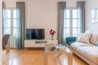 a living room with a couch and a tv at Sibs Bcn- Balmes- Romantic CityCentre Beautiful in Barcelona