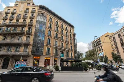 a car driving past a large building on a street at Sibs Bcn- Balmes- Romantic CityCentre Beautiful in Barcelona