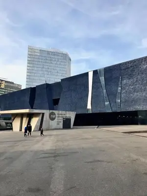 a large blue building with people walking in front of it at Nova Mar Bella Apartment in Barcelona