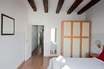 a bedroom with a white bed and a wooden ceiling at My Address in Barcelona Downtown in Barcelona