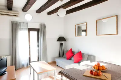 a living room with a couch and red pillows at My Address in Barcelona Downtown in Barcelona
