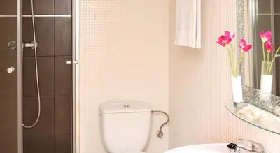 a bathroom with a toilet and a sink with pink flowers at My Address in Barcelona Downtown in Barcelona
