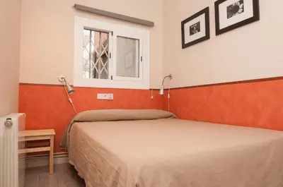 a small bedroom with two beds and a window at Charming Gracia 2 bedrooms in Barcelona