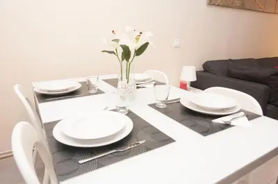 a dining room table with white plates and flowers on it at Charming Gracia 2 bedrooms in Barcelona