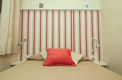 a bed with a red pillow on top of it at Charming Gracia 2 bedrooms in Barcelona